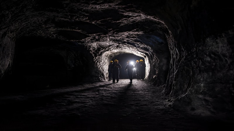 Workers are walking along the coal mine roadway, getting ready to go to work
